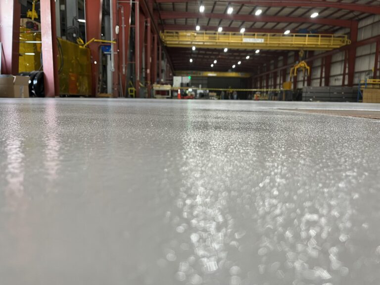 Low-angle view of the finished floor surface showing its textured sheen, American Steel and Aluminum, Auburn, MA