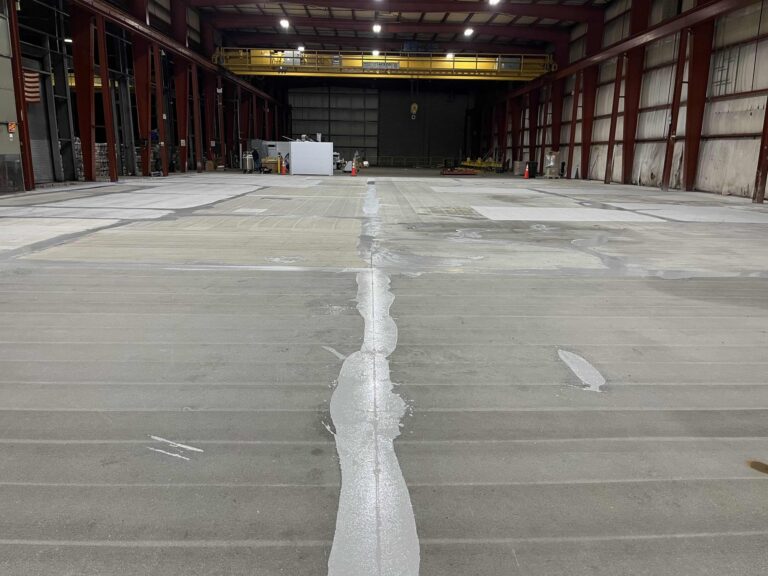 Prepared concrete slab in the fabrication bay with filled cracks before coating, May 2023, American Steel and Aluminum, Auburn, MA