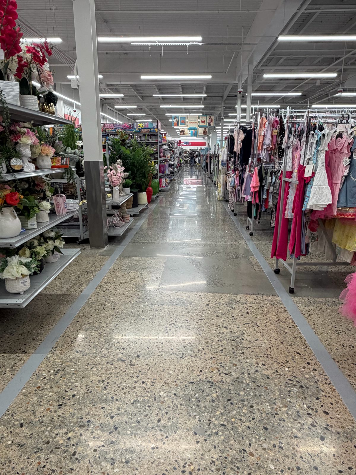 Retail & Grocery Flooring 3 Polished exposed-aggregate concrete aisle running between floral displays and apparel racks on the sales floor at Burlington, Walpole, MA
