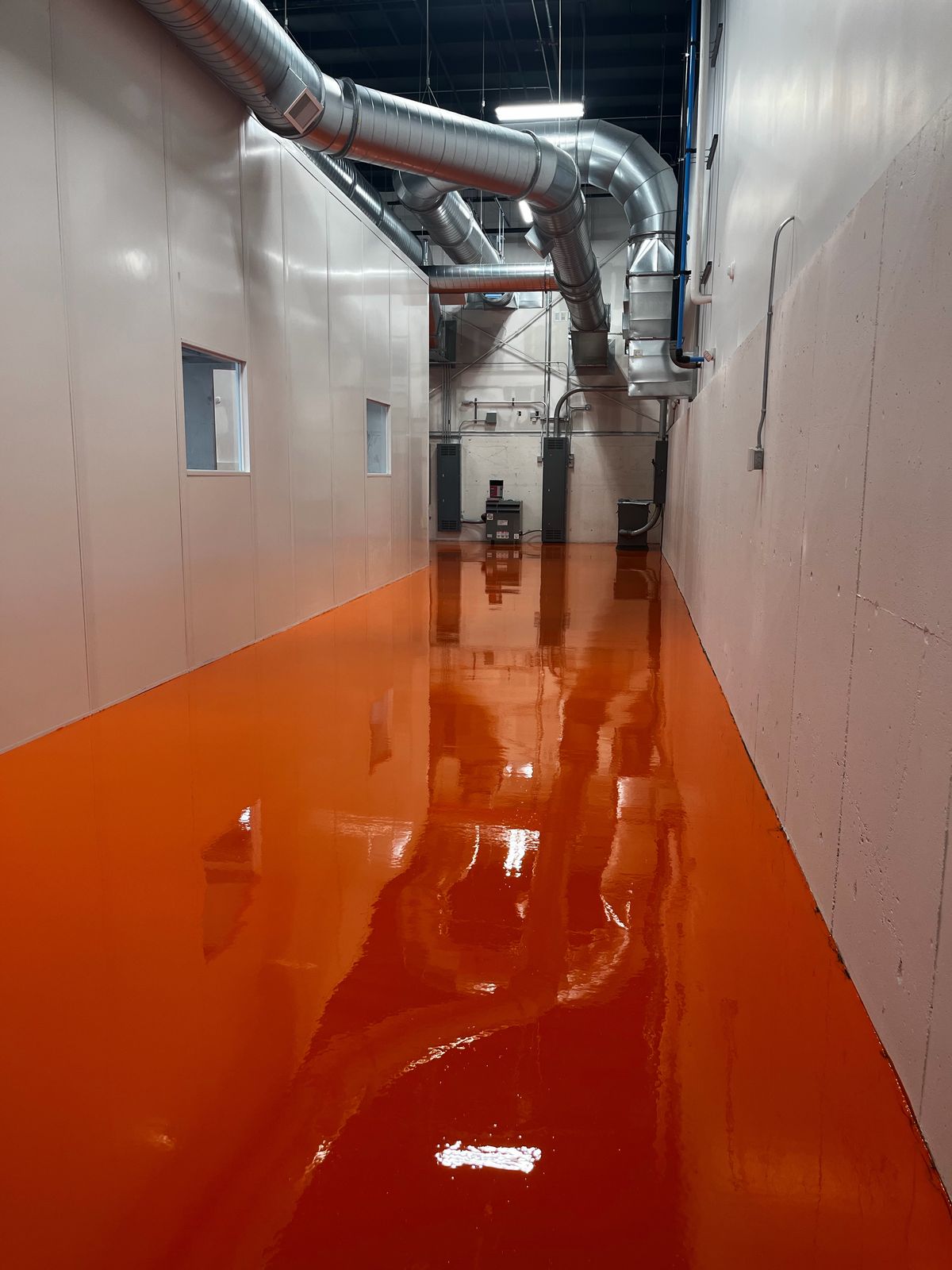 Glossy orange floor in a corridor with overhead ducts, High Purity New England, Smithfield, RI
