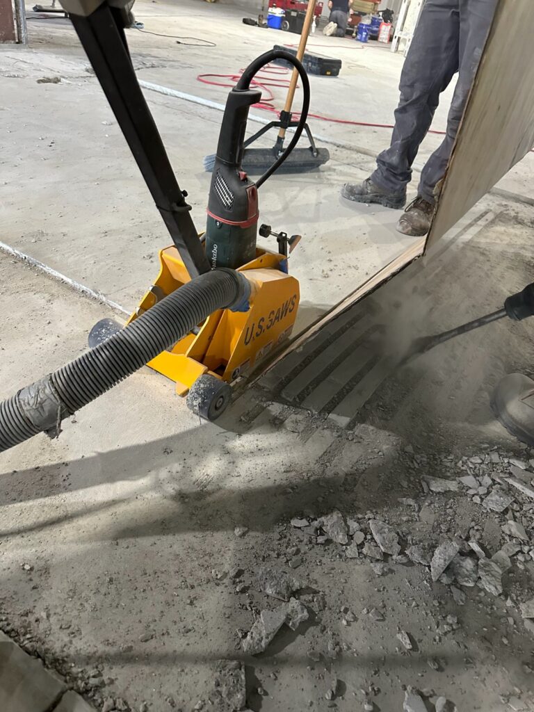 Saw cutting a concrete floor with dust extraction hose at L.L. Bean Outlet, Framingham