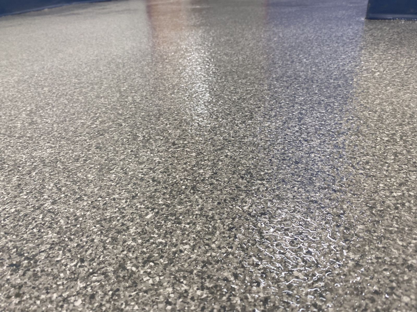 Flooring for Schools & Universities 11 Close-up of a gray decorative flake floor with a glossy clear topcoat