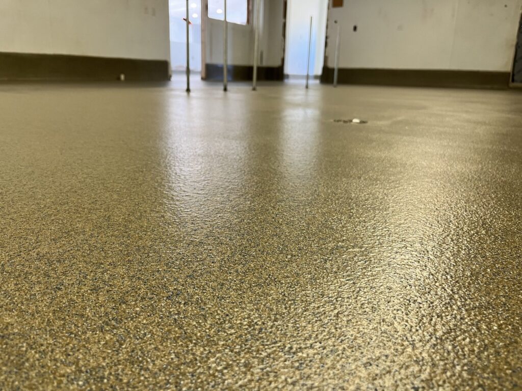 Decorative quartz epoxy floor with a textured speckled finish in a commercial interior