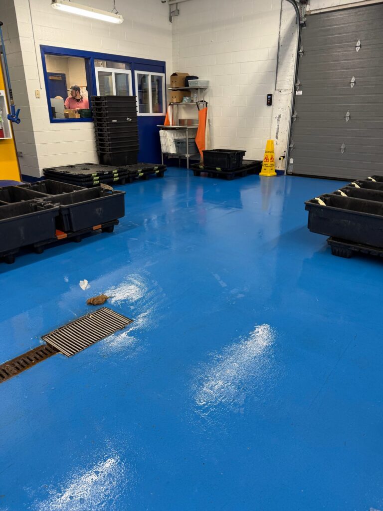 Blue floor with a trench drain, bins and an office window, Rocky Neck, Boston Fish Pier