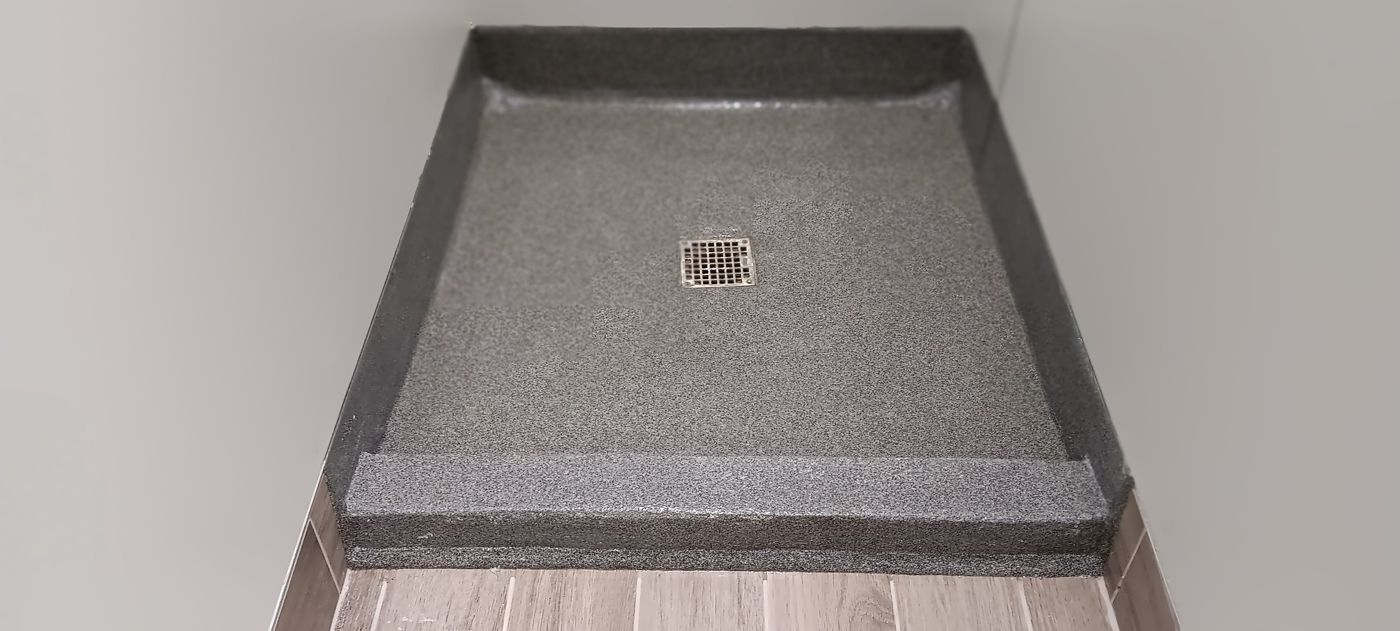Flooring for Schools & Universities 3 Finished gray Dur-a-Quartz shower floor with integral cove and a center drain, Boland Hall, Stonehill College, North Easton, MA