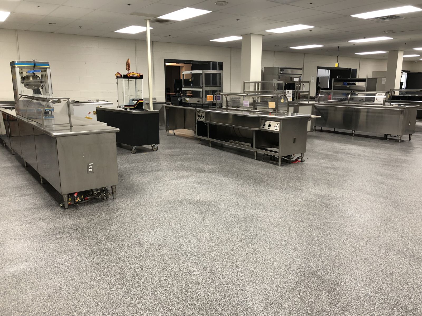 Flooring for Schools & Universities 4 Finished gray speckled resinous floor in a school servery with stainless steel serving counters, Taunton High School, Taunton, MA