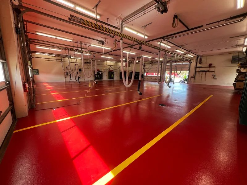 Finished red urethane cement floor with yellow safety striping in the apparatus bay in Eastham, MA